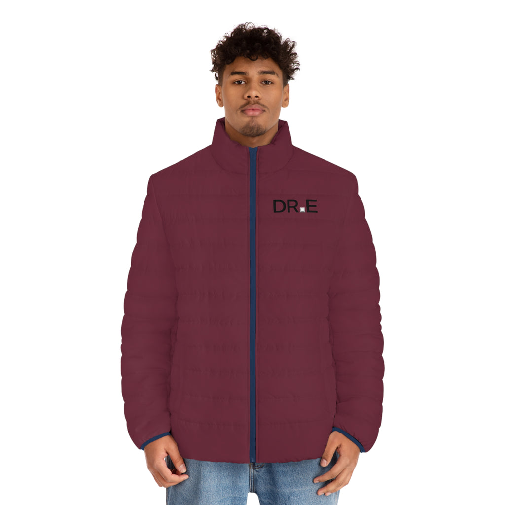 A man wearing a maroon quilted puffer jacket with a navy blue zipper and a black 'DR-E' logo on the left chest, paired with blue jeans, against a plain white background.